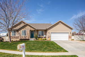 Ranch-style home featuring concrete driveway, stucco siding, a front yard, a garage, and fence