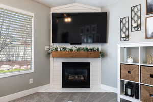 Living room with a tile fireplace, baseboards, and carpet floors
