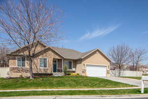 Ranch-style house with concrete driveway, stucco siding, a front yard, a garage, and fence