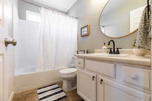 Full bathroom featuring toilet, vanity, and shower / tub combo with curtain