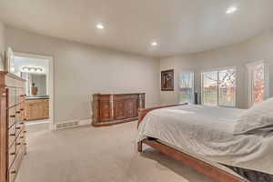 Bedroom featuring light colored carpet, ensuite bath, visible vents, recessed lighting, and baseboards