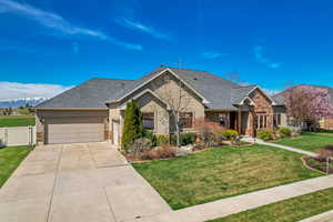 Single story home featuring stucco siding, fence, a front lawn, an attached garage, and concrete driveway