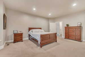 Bedroom with recessed lighting, visible vents, light colored carpet, and baseboards