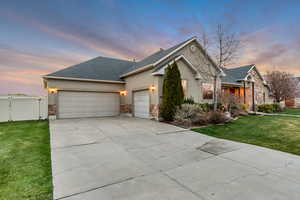 Single story home with a garage, a yard, driveway, and stucco siding