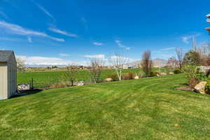 View of yard with a storage shed, a mountain view, and an outdoor structure