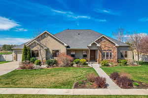 Craftsman inspired home with a garage, stucco siding, stone siding, and a front yard