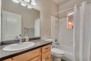 Full bath featuring shower / bathtub combination with curtain, vanity, and toilet