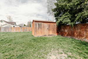 View of yard with a storage shed, an outbuilding, and a fenced backyard