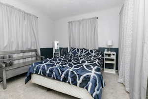 Carpeted bedroom featuring a textured ceiling