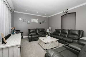 Living room with light carpet, recessed lighting, a textured ceiling, and crown molding