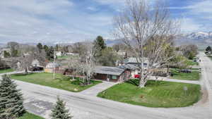 View of front of property with driveway, a mountain view, a front yard, and a residential view