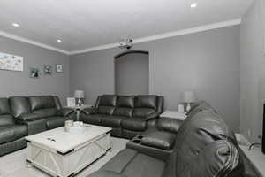 Living area with crown molding, light carpet, and recessed lighting