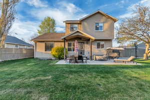 Back of property with a yard, a fenced backyard, stucco siding, and a patio area