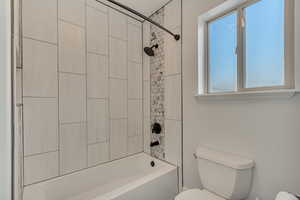 Full bathroom with toilet and shower / washtub combination