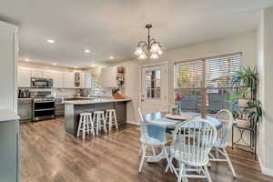 Dining area featuring wood finished floors, an inviting chandelier, baseboards, and recessed lighting