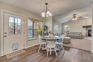 Dining room featuring a healthy amount of sunlight, a tiled fireplace, dark wood finished floors, and visible vents
