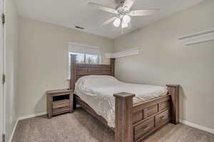 Bedroom with light carpet, visible vents, and baseboards