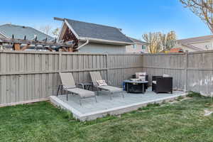Exterior space featuring a fire pit, a pergola, and fence private yard