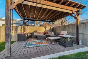 Wooden terrace with an outdoor living space and a fenced backyard