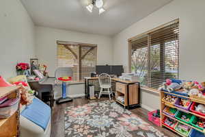 Office space featuring baseboards, wood finished floors, and a textured ceiling