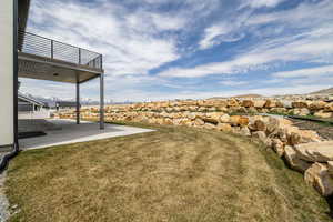 View of yard with a patio area, a balcony, and a mountain view