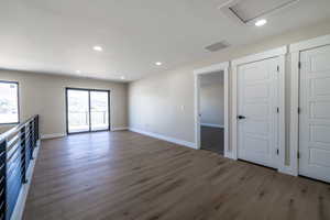 Unfurnished living room with visible vents, baseboards, recessed lighting, and wood finished floors