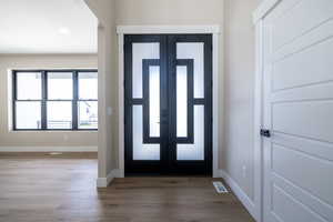 Entrance foyer with wood finished floors, baseboards, visible vents, and recessed lighting