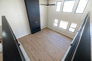 Empty room with light wood-style floors, baseboards, and a ceiling fan