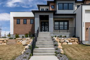 View of front facade with stucco siding and stone siding