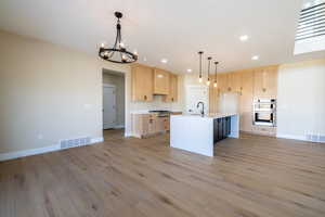 Kitchen with a chandelier, visible vents, light brown cabinetry, and appliances with stainless steel finishes