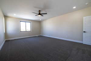 Empty room featuring visible vents, baseboards, dark carpet, a ceiling fan, and recessed lighting