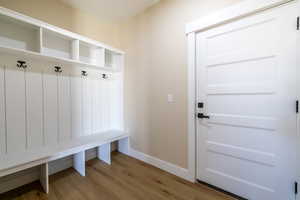 Mudroom with light wood finished floors and baseboards