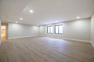 Spare room with light wood-type flooring, baseboards, and recessed lighting