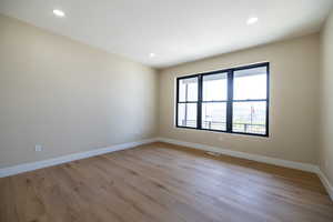 Spare room with recessed lighting, light wood-style flooring, and baseboards