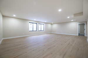 Spare room with light wood-type flooring, baseboards, and recessed lighting