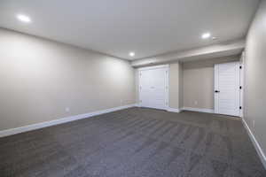 Unfurnished bedroom featuring dark colored carpet, recessed lighting, and baseboards