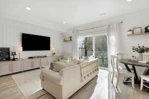 Living room with visible vents, light wood-type flooring, and recessed lighting