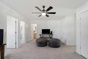 Living area with baseboards, a ceiling fan, visible vents, and carpet floors