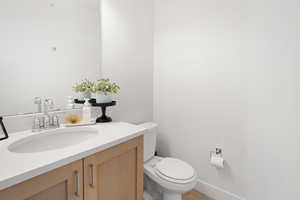 Half bath featuring toilet and vanity