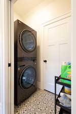 Washroom featuring stacked washing maching and dryer and laundry area