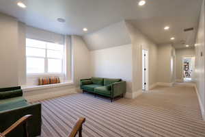 Interior space featuring carpet floors, baseboards, recessed lighting, and lofted ceiling