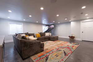 Living area featuring baseboards, recessed lighting, finished concrete floors, and a healthy amount of sunlight