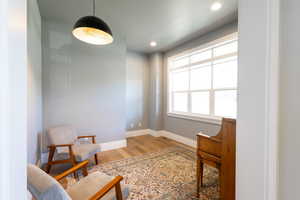Sitting room with baseboards, light wood finished floors, and recessed lighting