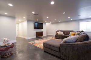 Family room featuring recessed lighting, baseboards, and concrete flooring
