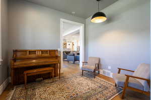 Sitting room featuring visible vents, baseboards, and wood finished floors