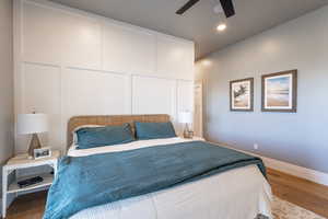Main floor master suite with recessed lighting, baseboards, a ceiling fan, and wood finished floors