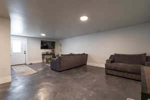 ADU Living room featuring concrete flooring and baseboards