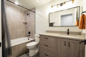 Full bath featuring toilet, tiled shower / bath, and vanity