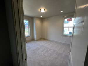 Empty room with light colored carpet, baseboards, and recessed lighting
