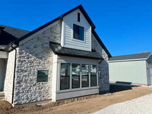 Front of house featuring cement board and stone siding